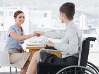 Businesswoman Shaking Hands With Disabled Colleague