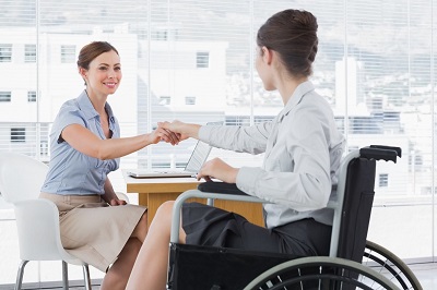 Businesswoman Shaking Hands With Disabled Colleague